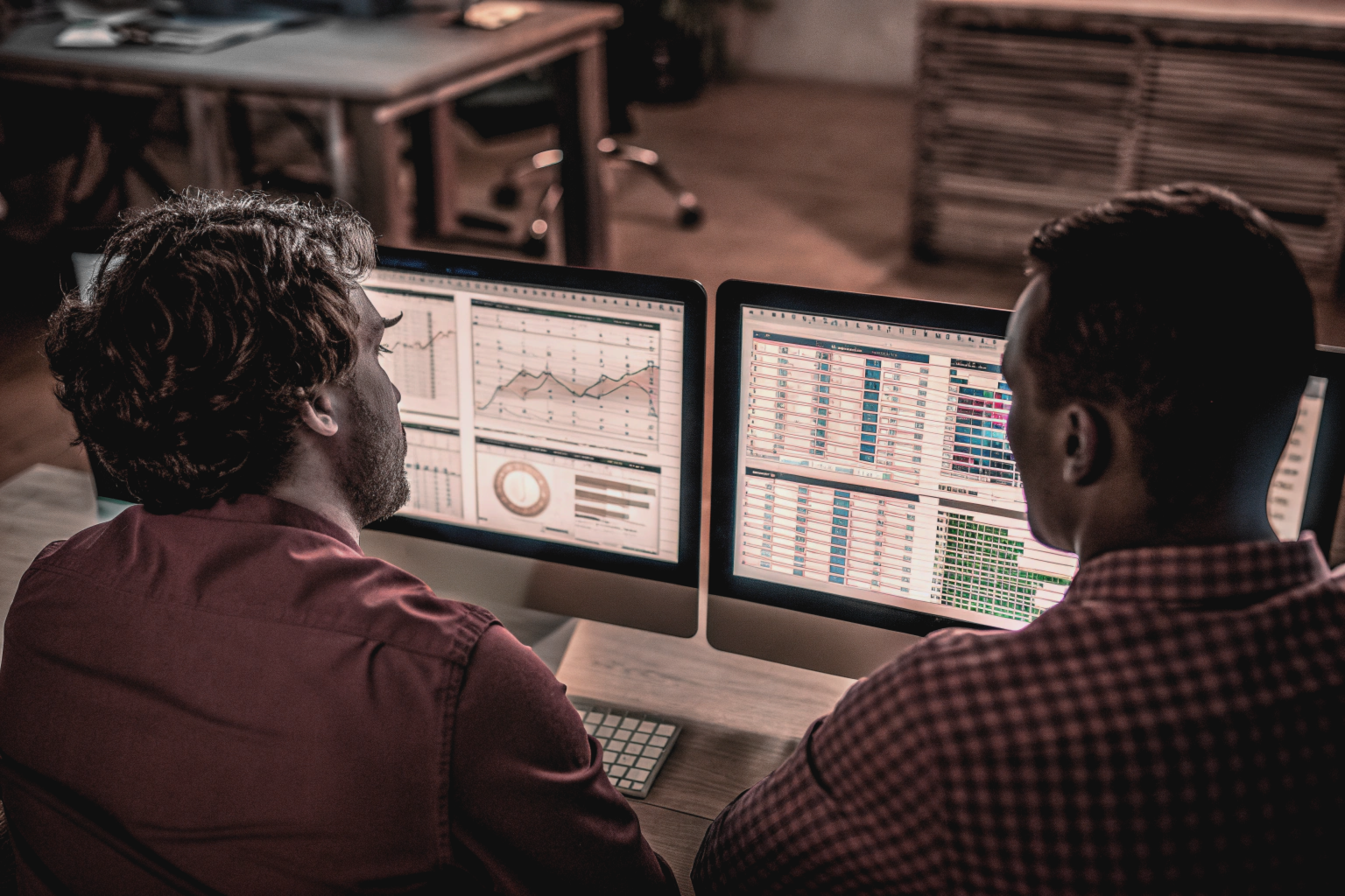 Analysts reviewing SEO case studies and benchmarks on screens with charts and graphs showing traffic, rankings, and conversions.
